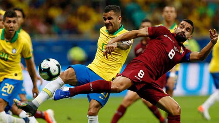 Tomas Rincon berusaha menggagalkan tendangan Dani Alves dalam laga Copa America 2019 fase grup di Arena Fonte Nova, Rabu (19/06/19).