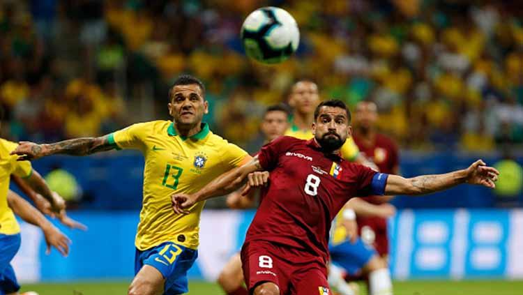 Dani Alves dan Tomas Rincon tengah adu badan untuk merebut bola dalam laga Copa America 2019 fase grup di Arena Fonte Nova, Rabu (19/06/19).