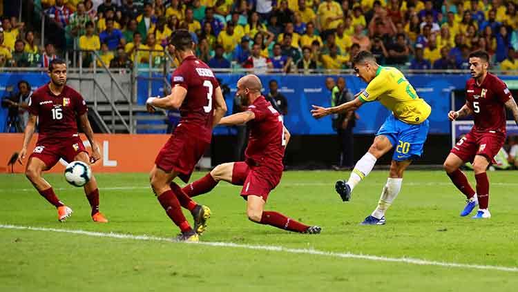 Roberto Firmino tengah mengeksekusi bola ke arah gawang Venezuela dalam laga Copa America 2019 fase grup di Arena Fonte Nova, Rabu (19/06/19).