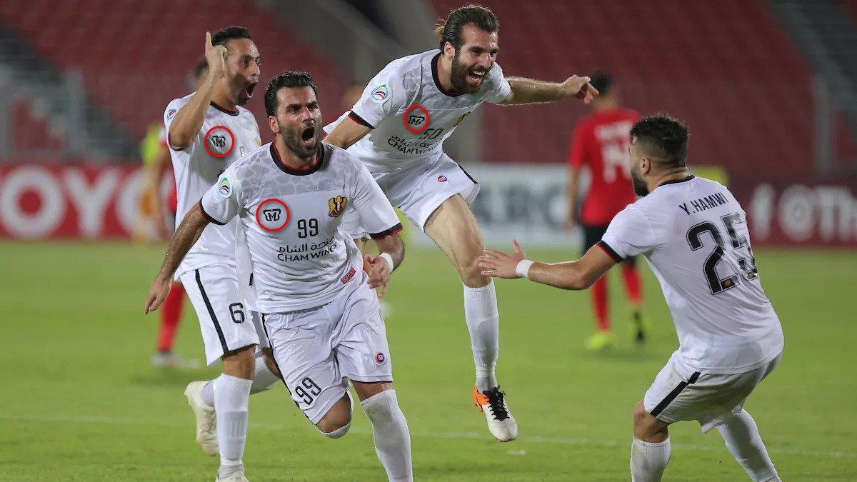 Skuat Al Jaish dengan sponsor jersey dari MBB Apparel, merayakan kemenangan mereka di leg pertama semifinal Piala AFC 2019 - INDOSPORT