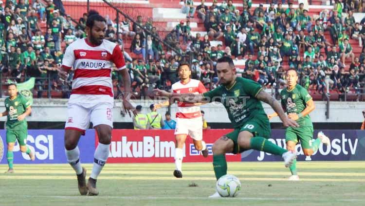 Pemain Persebaya, Damian Lizio saat dihadang oleh pemain Madura United pada Piala Indonesia di Stadion Gelora Bung Tomo, Rabu (19/06/2019). Foto: Fitra Herdian/INDOSPORT - INDOSPORT