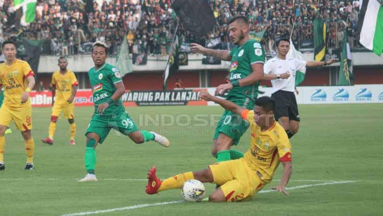 Pemain Bhayangkara FC menjegal pemain PSS Sleman. Copyright: Ronald Seger Prabowo/INDOSPORT