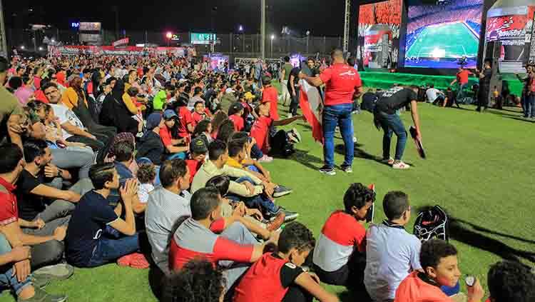 Masyarakat Mesir menyaksikan laga pembukan Piala Afrika Mesir vs Zimbabwe di layar besar luar stadion.
