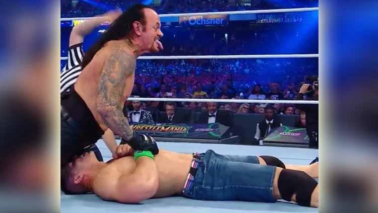 Superstar WWE, John Cena dan Undertaker saat berhadapan di atas ring. Foto: thesun/WWE Copyright: thesun/WWE