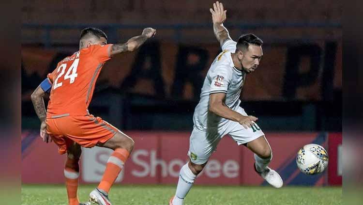 Diego Michiels (kiri) membayangi pergerakan Damian Lizio yang menguasai bola, Minggu (23/06/2019).