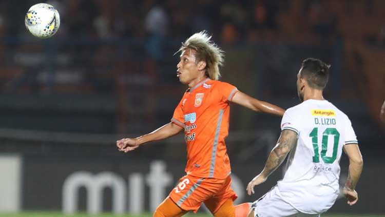 Asri Akbar (kiri) mencoba menguasai bola saat dibayang-bayangi Manucekhr Jalilov, Minggu (23/06/2019).