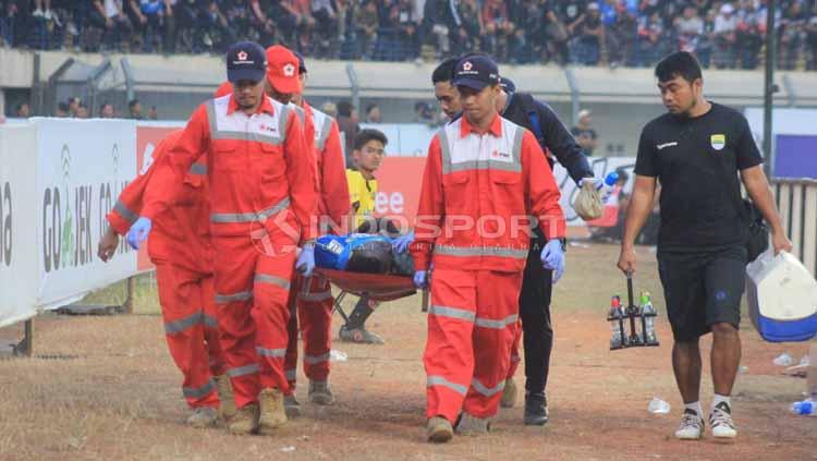 Tim medis menandu striker Persib Bandung, Ezechiel N'Douassel saat pertandingan menghadapi Madura United di Stadion Si Jalak Harupat, Kabupaten Bandung, Minggu (23/06/2019). Foto: Arif Rahman/INDOSPORT - INDOSPORT