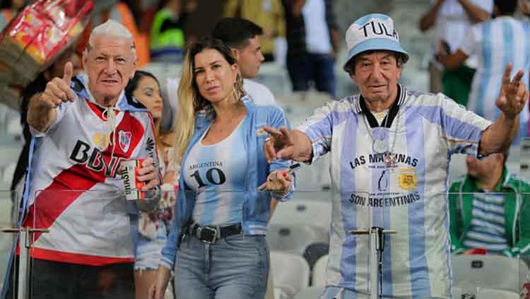 Satu wanita, dua laki-laki tampak semangat memberikan dukungan kepada para pemain Argentina yang tengah berlaga melawan Paraguay di fase grup Copa America 2019 (19/06/19). Gustavo Ortiz/Jam Media/Getty Images