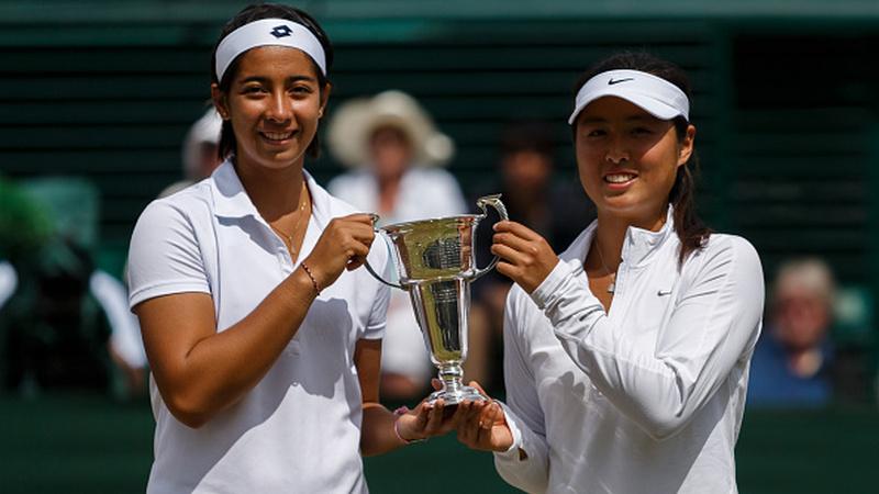 Tami Grende dan Qiu Yu Ye, memegang trofi girl's doubles di Wimbledon 2014 - INDOSPORT