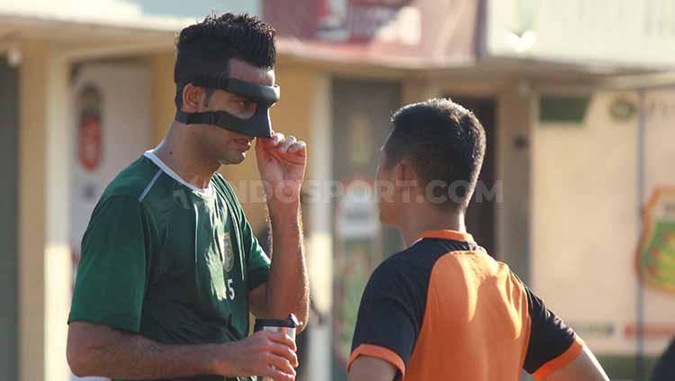 Otavio Dutra berbincang dengan dokter Persebaya mengenai maskernya saat latihan di Lapangan Polda Jatim, Selasa (25/6/19). Copyright: Fitra Herdian/INDOSPORT