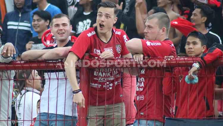 Para wisatawan luar negeri saat memberikan dukungan pada Bali United dalam laga lawan PSIS Semarang di tribun selatan Stadion Kapten I Wayan Dipta, Gianyar, Sabtu (22/6/2019).
