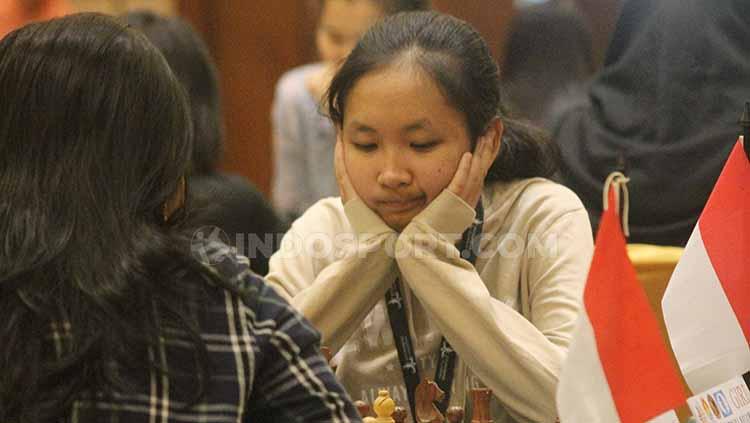 Pecatur Indonesia, Ummi Fisabilillah mengamati bidak dalam ajang Asian Juniors Chess Championship (AJCC) 2019 di Hotel Lorin, Karanganyar. - INDOSPORT