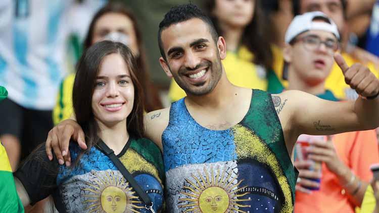 Sepasang kekasih tersenyum ke arah kamera di laga semifinal Copa America antara Brasil vs Argentina di Mineirao Stadium, Rabu (03/07/19). Bruna Prado/Getty Images