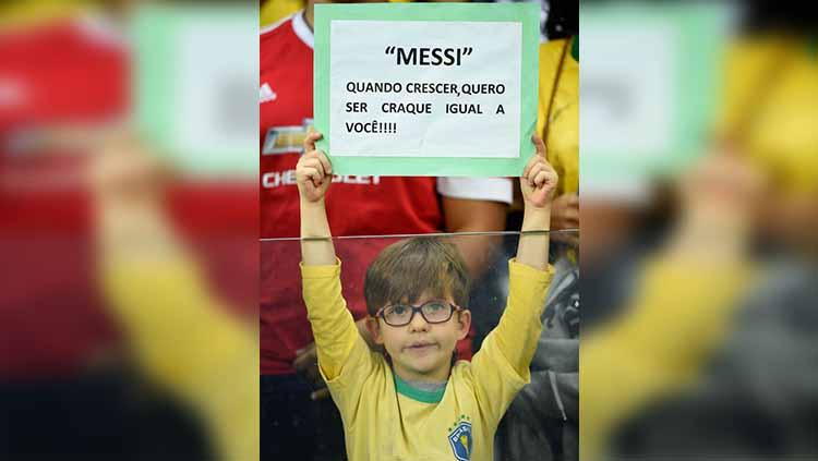 Suporter cilik Brasil dengan poster berisi harapan ingin menjadi seperti Messi saat sudah besar pada laga semifinal Copa America di Mineirao Stadium, Rabu (03/07/19). Pedro Vilela/Getty Images