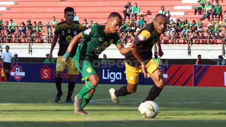 Irfan Jaya duel dengan salah satu pemain Barito Putera di Stadion GBT. Copyright: Fitra herdian/INDOSPORT