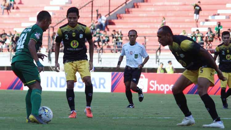 Irfan Jaya tampak fokus berusaha melewati dua pemain Barito Putera. Copyright: Fitra herdian/INDOSPORT