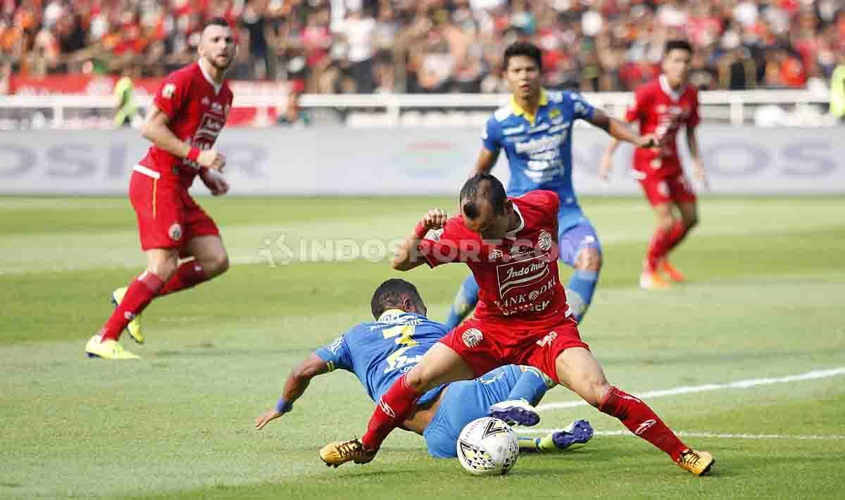 Riko Simanjuntak merebut bola dari pemain Persib. Copyright: Herry Ibrahim/INDOSPORT