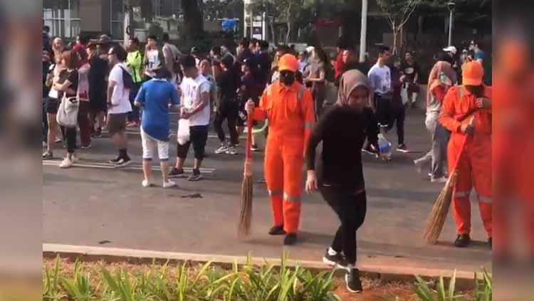 Aksi Liliyana Natsir menyamar jadi tukang sapu di Car Free Day. Foto: Twitter@RudyRoedyanto - INDOSPORT