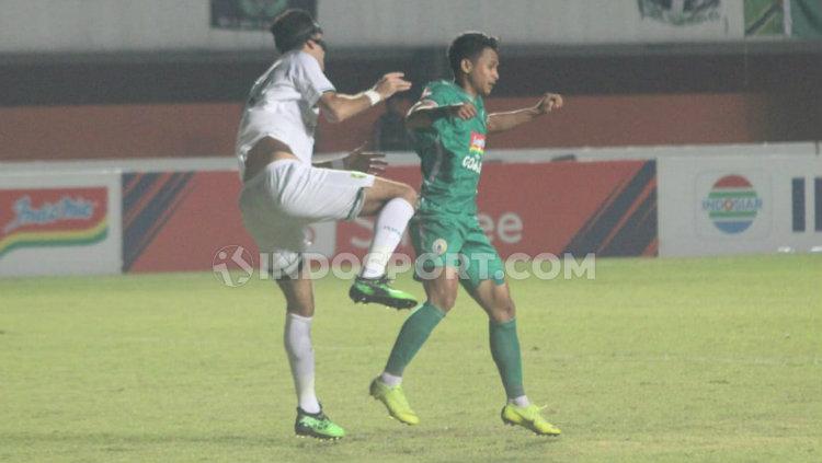 Winger muda PSS Sleman, Irkham Zahrul Milla (kanan) berduel dengan bek Persebaya, Otavio Dutra. Foto: Ronald Seger Prabowo/INDOSPORT