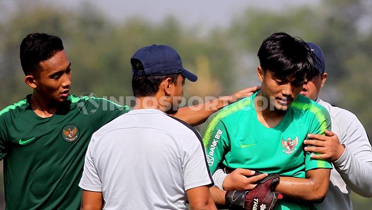 Ernando memegang tangannya yang cedera saat latihan di Lapangan Jenggolo, Sidoarjo.