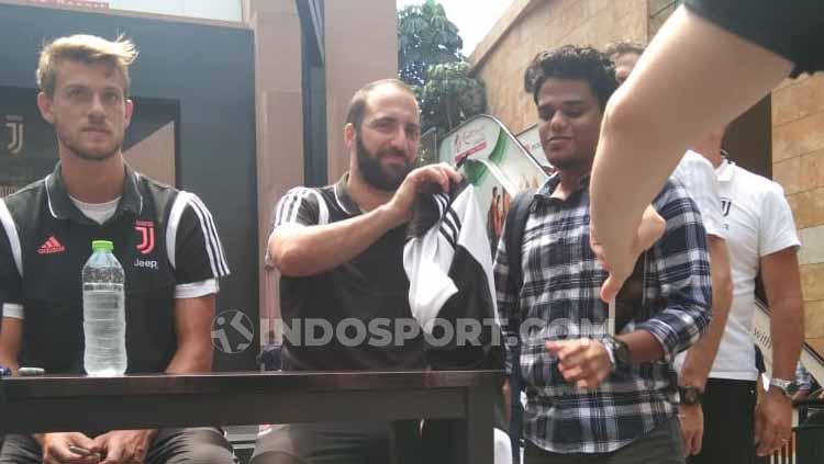 Gonzalo Higuain tersenyum ketika wartawan INDOSPORT memanggilnya saat sedang memberi tanda tangan pada fans Juventus Copyright: Theresia R. Simanjuntak/INDOSPORT