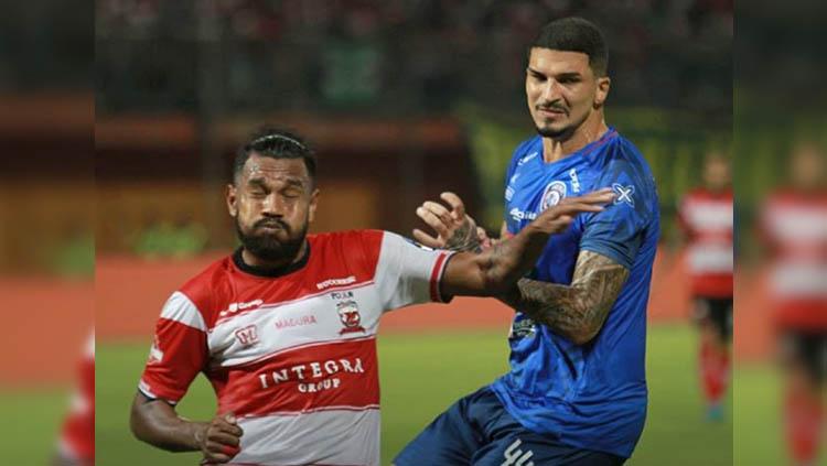 Fandry Imbiri (kiri) dikawal Arthur Cunha (kanan) pada laga Madura United vs Arema FC di Stadion Gelora Ratu Pamelingan dalam lanjutan pekan ke-10 Liga 1 2019, Sabtu (20/07/19). Copyright: Instagram/@aremafcofficial