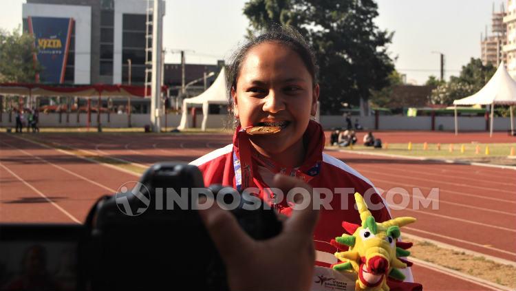 Atlet lempar martil Natasha Mahdalita saat menunjukkan medali emas yang didapatkannya di ASEAN School Games 2019. Foto: Alvin Syaptia Pratama/INDOSPORT - INDOSPORT