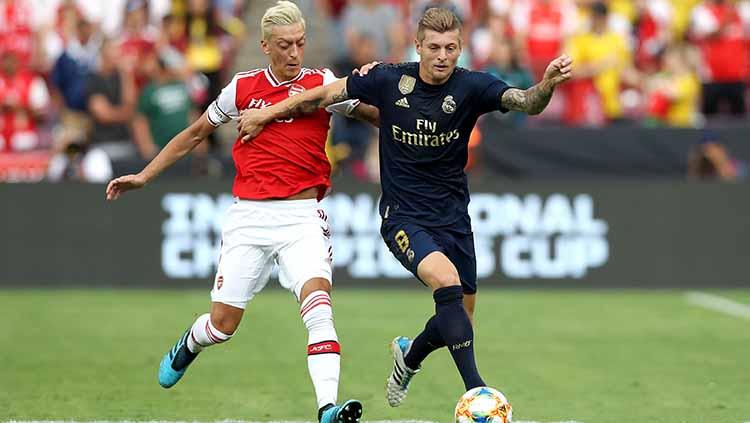 Mesut Ozil berusaha merebut bola dari Toni Kroos pada laga ICC 2019 di stadion FedExField (24/07/19).