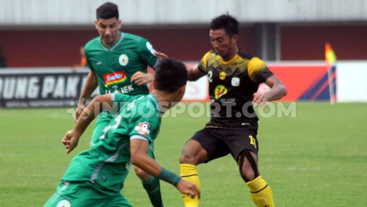 Gelandang Barito Putera, Bayu Pradana (kanan) mengawal pemain PSS Sleman, Brian Ferreira dalam laga di Stadion Maguwoharjo