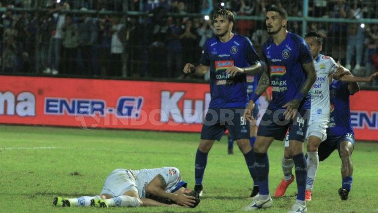 Pemain Persib Bandung, Rene Mihelic terjatuh di pertahanan Arema FC pada pertandingan pekan ke-11 Liga 1 2019. INDOSPORT/Ian Setiawan. - INDOSPORT