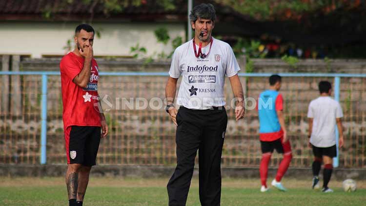 Gelandang Bali United, Brwa Nouri (kiri) saat mendengarkan intruksi pelatihnya, Stefano Cugurra Teco, dalam sesi latihan di Lapangan Samudra, Legian, Kuta, Badung, Senin (5/8/19).