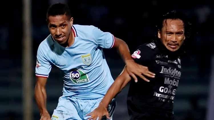 Hariono duel dengan pemain Persela Lamongan untuk mendapatkan bola. Copyright: perselafc