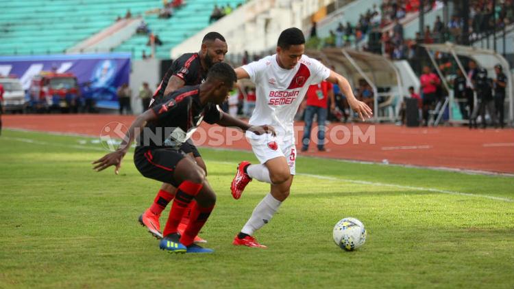 Reva Adi Utama (putih) berusaha melewati dua pemain Persipura Jayapura. Copyright: Adriyan Adirizky/INDOSPORT