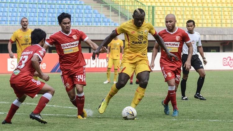 Indosport - Hariyanto Panto (dua dari kanan) berusaha merebut bola dari Herman Dzumafo.