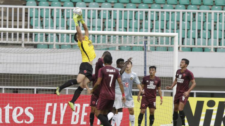 Kiper PSM Makassar, Rivky Mokodompit (kuning), menangkap bola di udara saat melawan Kaya FC pada penyisihan grup Piala AFC 2019 di Stadion Pakansari, Bogor. - INDOSPORT