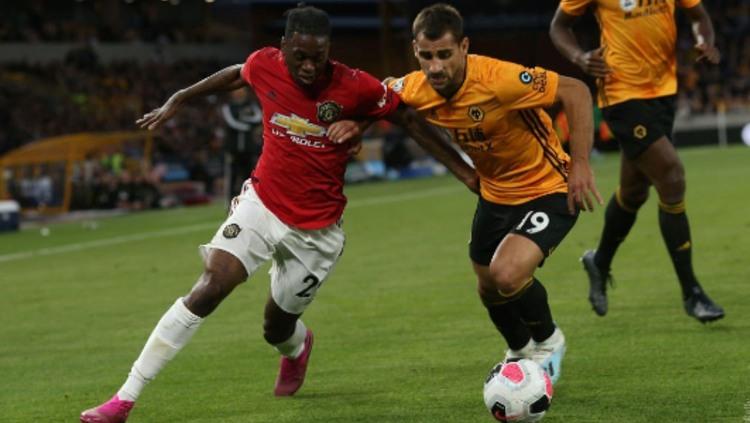 Aaron Wan-Bissaka berusaha merebut bola dalam pertandingan Wolverhampton vs Manchester United - INDOSPORT