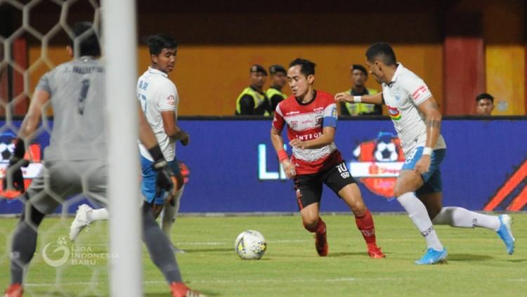 Slamet Nurcahyo berusaha melewati Patrick Mota dalam pertandingan Liga 1 2019 antara Madura United vs PSIS Semarang, Sabtu (24/8/19).
