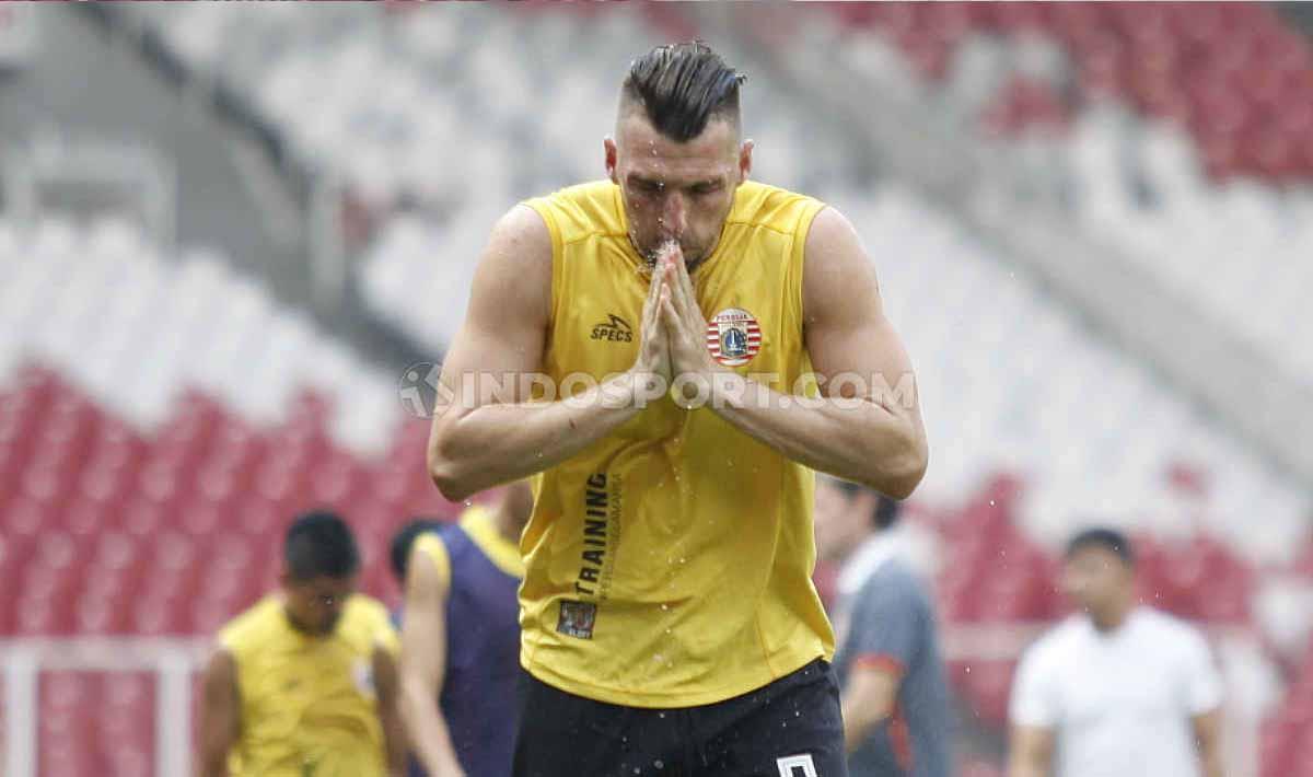 Striker Persija, Marko Simic membasuh wajahnya dengan air di sela-sela latihan tim Persija Jakarta jelang laga Liga 1 melawan PSM Makassar di Stadion GBK Senayan, Jakarta, Selasa (27/08/19). Foto: Herry Ibrahim/INDOSPORT