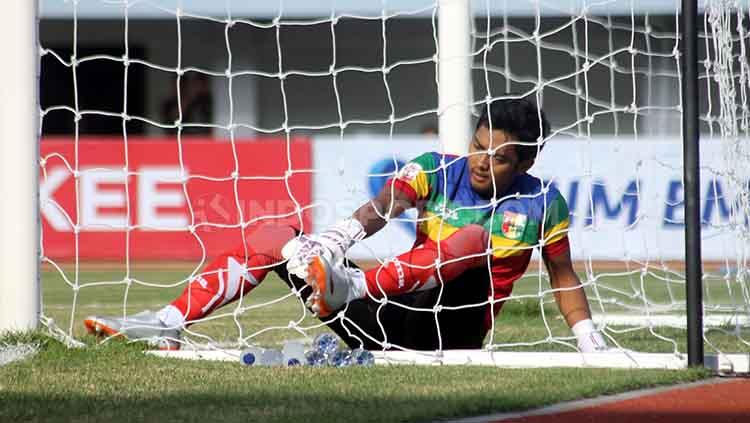 Kiper Mitra Kukar, M Rizki Darmawan coba mengeluarkan kaki yang tersangkut di jaring saat melawan PSIM Yogyakarta. Foto: Ronald Seger Prabowo/INDOSPORT