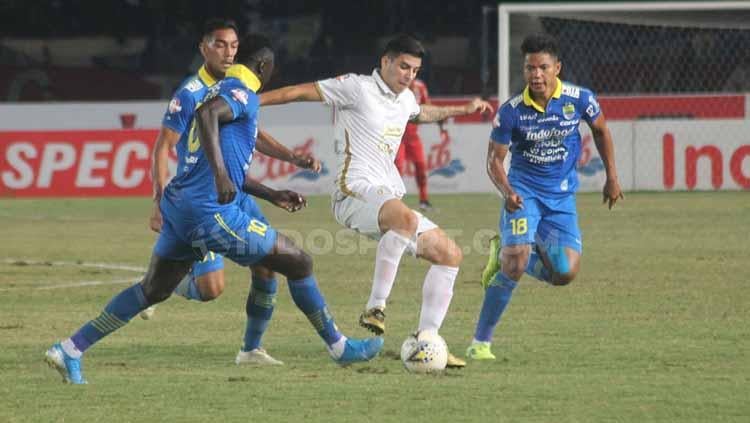Satu pemain PSS Sleman berusaha melewati tiga pemain Persib Bandung sekaligus. Copyright: Ronald Seger Prabowo/INDOSPORT