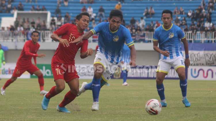 Gelandang Timnas U-22, Natanael Siringoringo berduel merebut bola dengan bek PSIM, Achmad Mahrus Bahtiar.