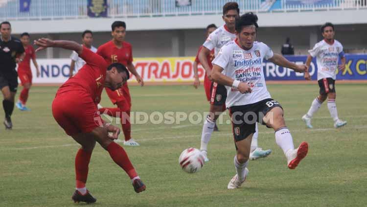 Bek Timnas U-22, Asnawi Mangkualam Bahar saat menendang bola untuk memberikan umpan tarik ke dalam kotak penalti Bali United.