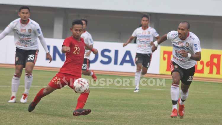 Sani Rizki berusahan menendang bola yang dikelilingi oleh para pemain Bali United.