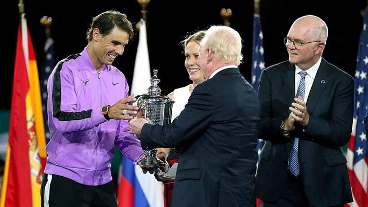 Rafael Nadal menerima trofi AS Terbuka 2019 dari legenda tenis, Rod Laver.