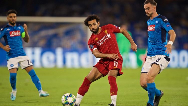 Pemain Liverpool, Mohamed Salah, berduel dengan dua pemain Napoli di matchday pertama Liga Champions 2019/20, Rabu (18/9/19) dini hari WIB. Copyright: Twitter @LFC