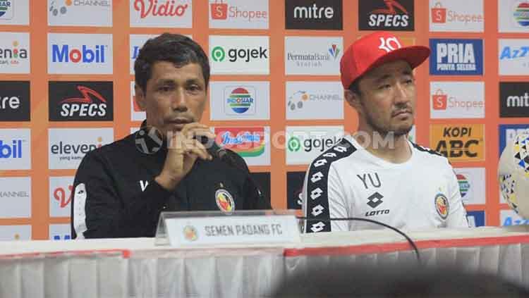 Asisten pelatih Semen Padang, Weliansyah (kiri) ditemani pemainnya Yu Hyunkoo saat konferensi pers di Stadion Si Jalak Harupat, Kabupaten Bandung, Rabu (18/09/2019). - INDOSPORT