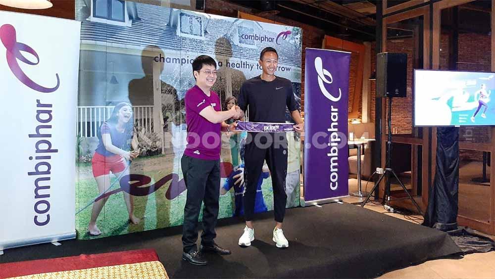 Lim Soeyantho, Chief Operating Officer & Member of Board of Director Combiphar (kiri) menyerahkan kategori EKIDEN kepada Agung Mulyawan, Running Coach (kanan) pada press conference Combi Run 2019 di Jakarta (20/09/19). - INDOSPORT