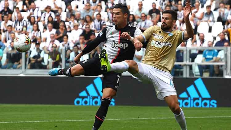 Cristiano Ronaldo dan Nenad Tomovic berduel untuk mengamankan bola. Copyright: Marco Luzzani/Getty Images