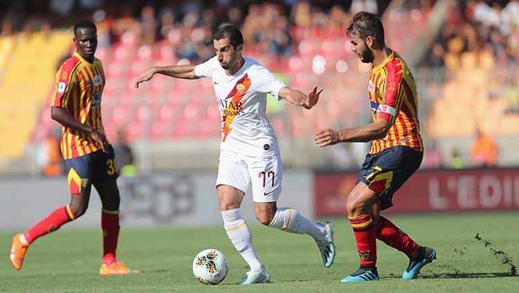 Henrick Mkhitaryan berusaha keluar dari serangan dua pemain Lecce. Copyright: Maurizio Lagana/Getty Images