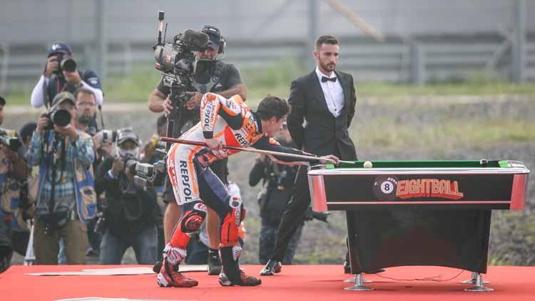 Aksi Marc Marquez berusaha memasukan bola billiar usai dinobatkan menjadi juara MotoGP 2019.